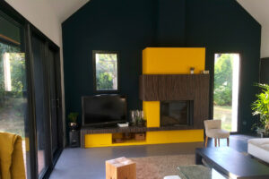 rénovation maison double hauteur cheminée jaune vert foncé béton ciré menuiserie coulissante aluminium noir