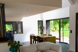 rénovation agrandissement maison double hauteur salle à manger cuisine béton ciré menuiserie aluminium noir